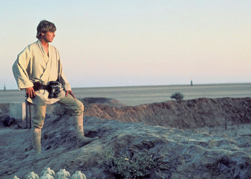 Luke Skywalker posando sobre una duna de un desierto desolado.