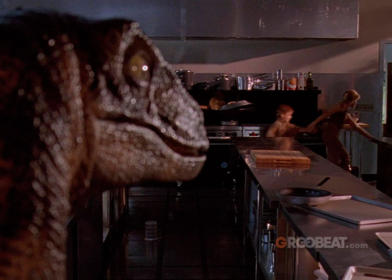 Velociraptor observando a los niños mientras huyen de él.