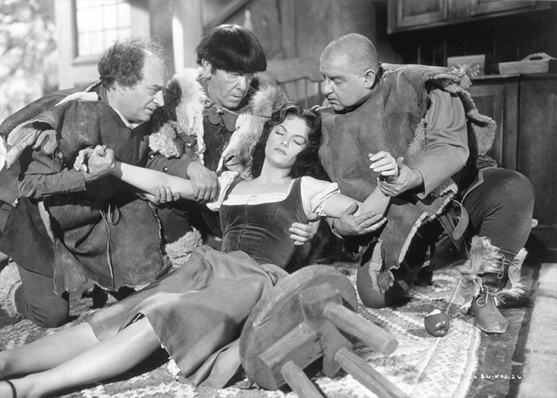 Blanca Nieves dormida es sostenida por los Tres Chiflados.