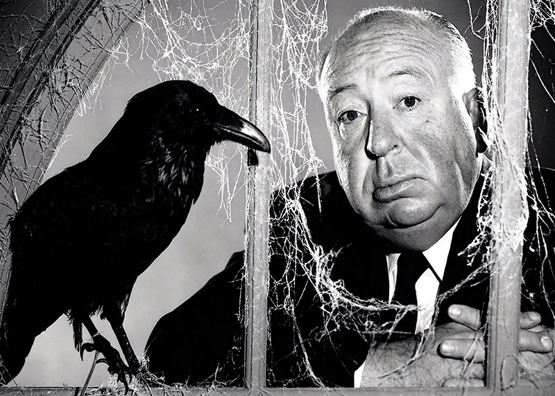 Alfred Hitchcock posando junto a un cuervo.