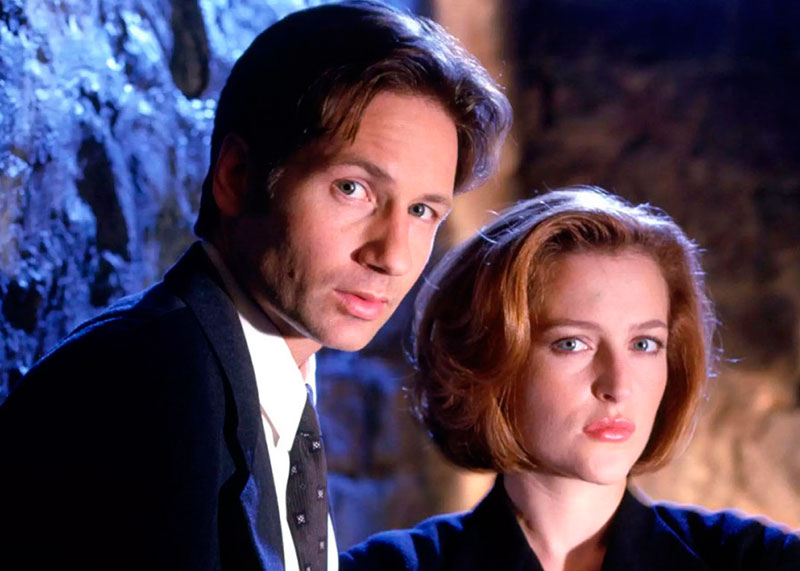 Los agentes Mulder y Scully juntos, mirando directamente al espectador.