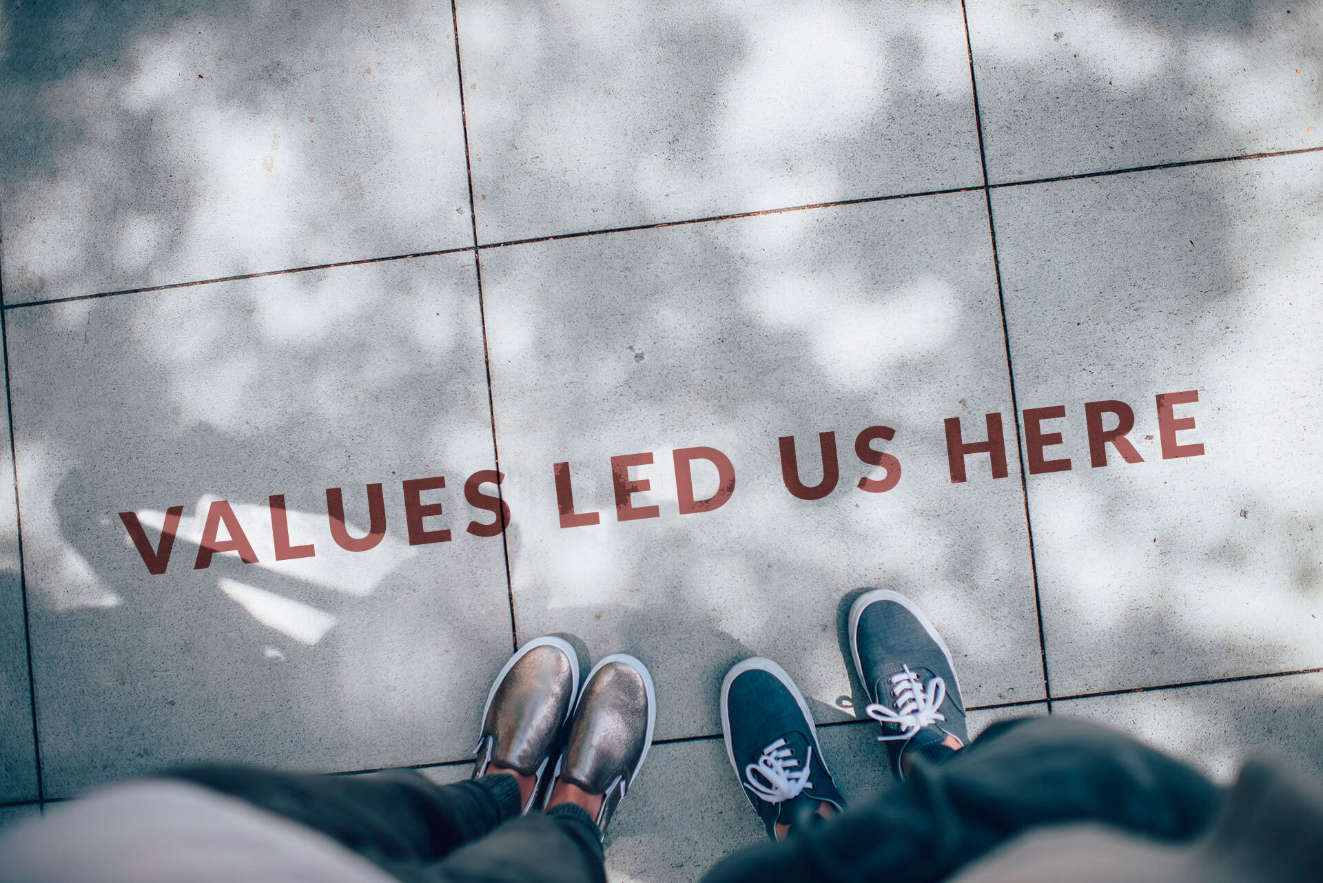 Partners side by side looking at the sign that says values led us here.